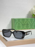 Gucci sunglasses with black frames and dark lenses, wide cat-eye shape