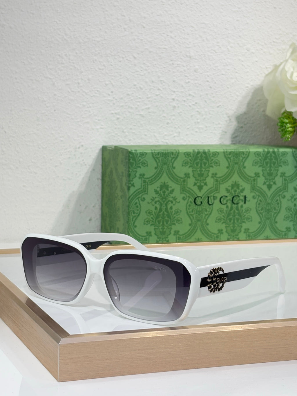 Gucci sunglasses with white frames and dark lenses, wide cat-eye design