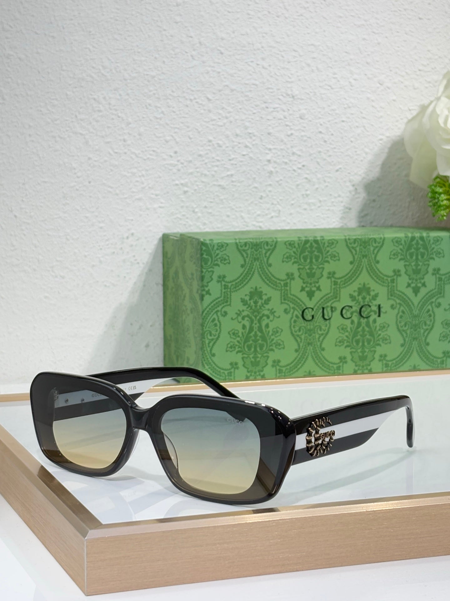 Gucci sunglasses with black frames and tinted blue lenses, cat-eye silhouette
