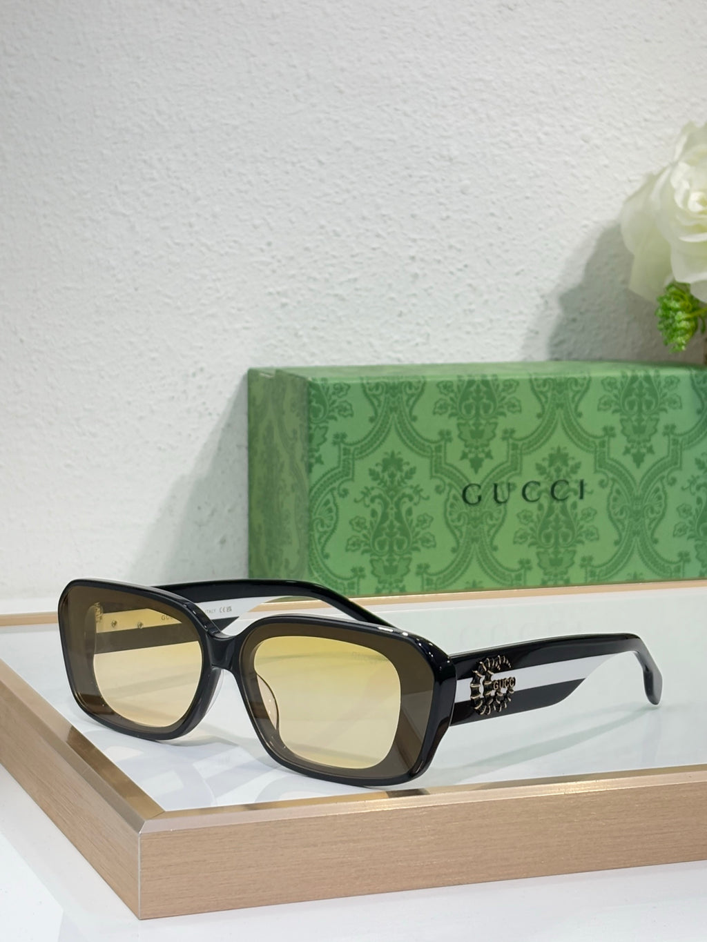Gucci sunglasses with dark frames and light yellow lenses, cat-eye shape