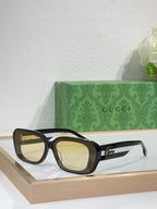 Gucci sunglasses with dark frames and light yellow lenses, cat-eye shape