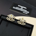 Chanel earrings with gold-tone CC logo and green pin detail on black fabric backing