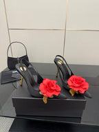 Black slingback heels with red rose clips and gold stiletto heels, side view