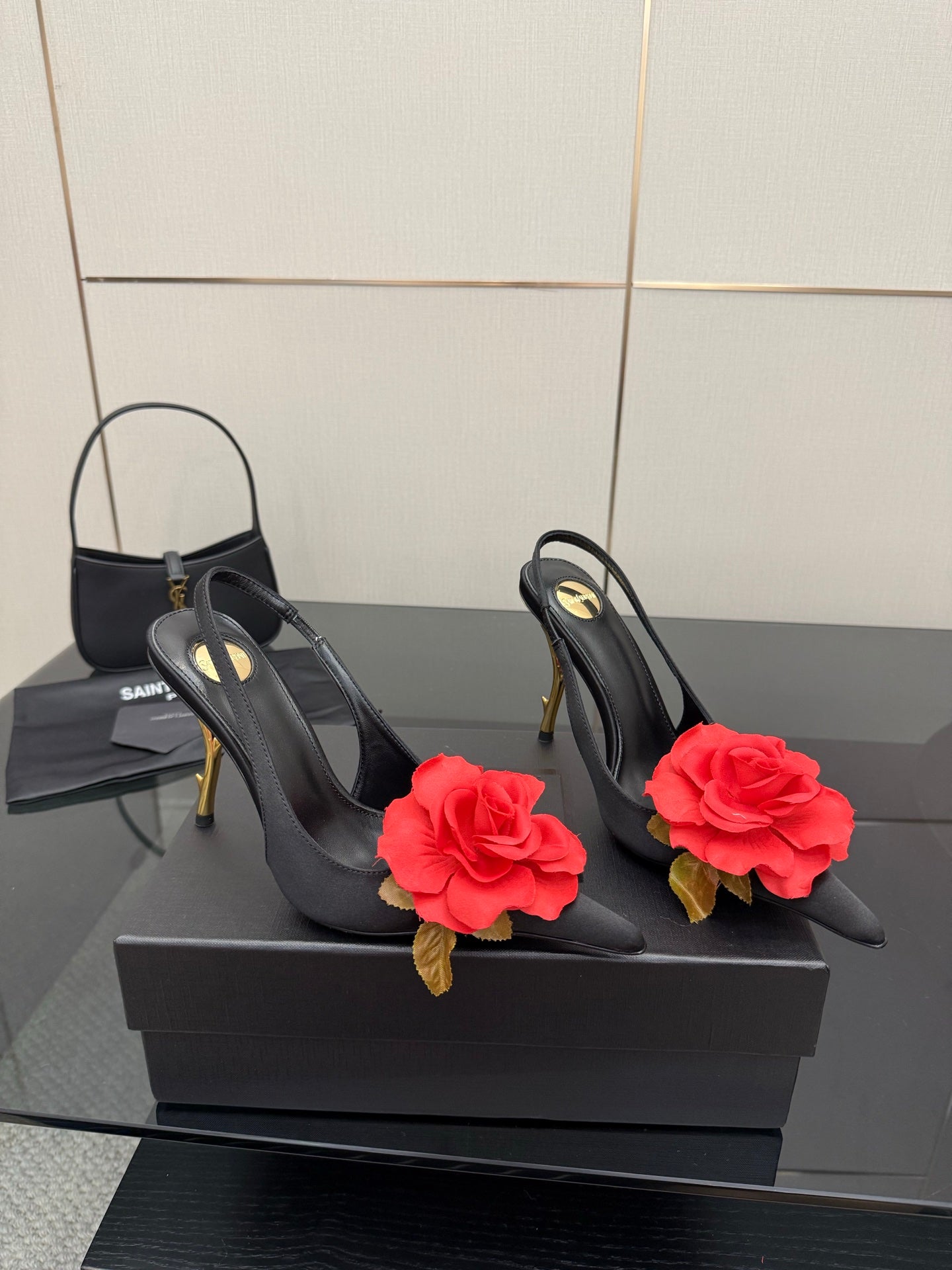Black slingback heels with red rose clips and gold stiletto heels, side view