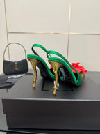 Green satin slingback heels with red flower accents and gold-tone stiletto heels