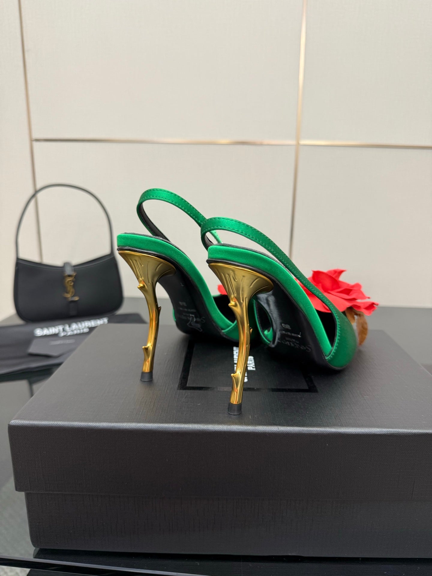 Green satin slingback heels with red flower accents and gold-tone stiletto heels