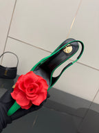 Green slingback pump with red flower on toe, black inner sole, and gold-tone heel