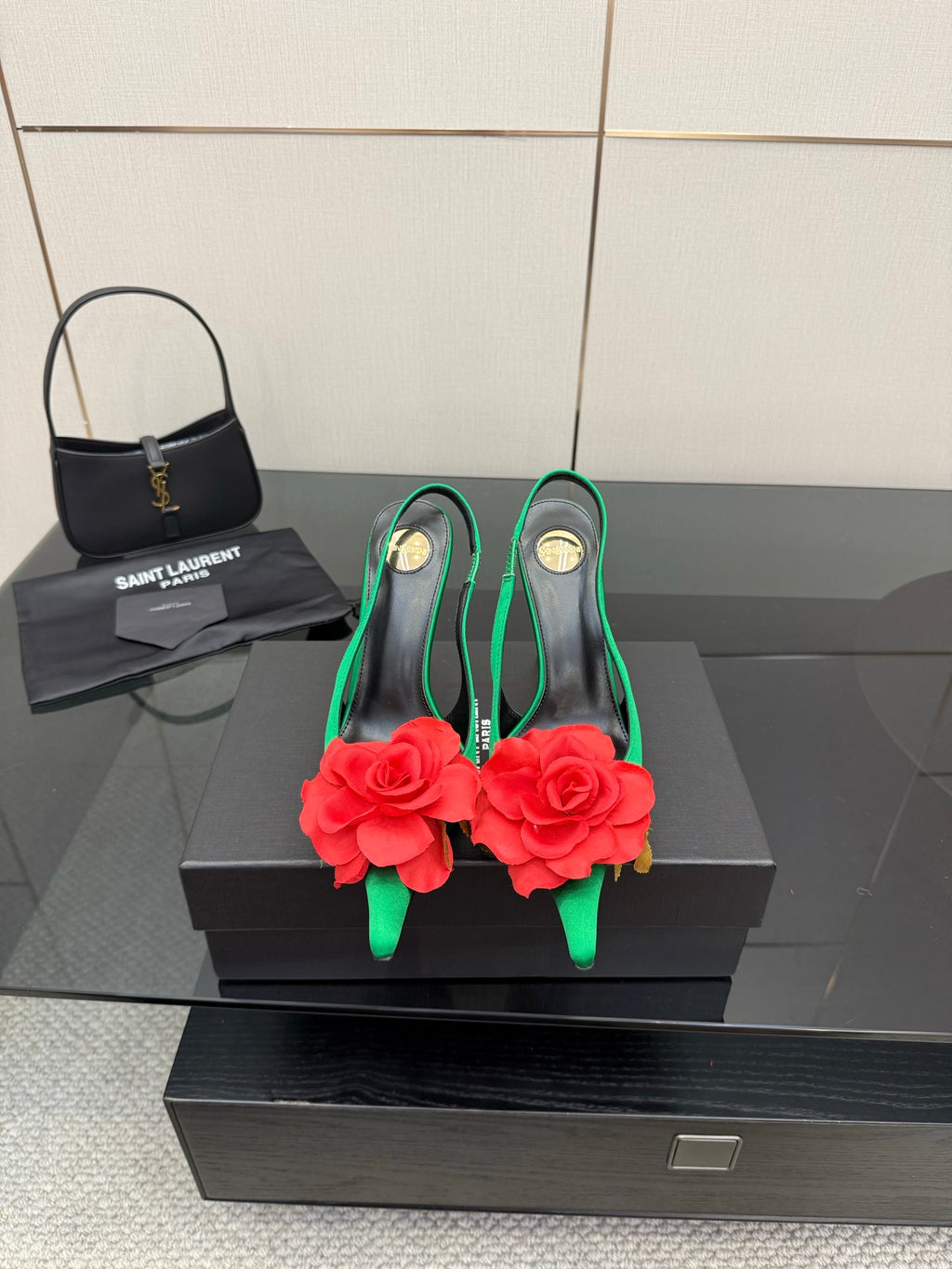 Green satin slingback heels with red flower embellishment and gold-tone stiletto heels