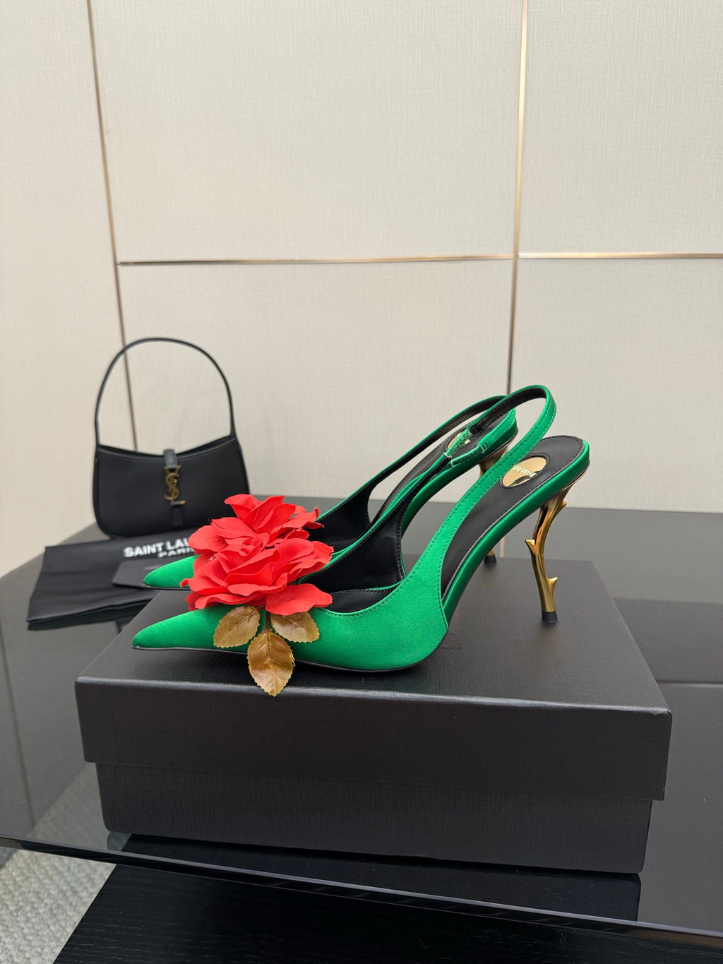 Green slingback pumps with red flower detail on toe and slender gold-tone stiletto heel
