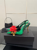 Green slingback pumps with red flower detail on toe and slender gold-tone stiletto heel