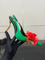 Green slingback heel with pointed toe, red flower detail, and gold-tone stiletto heel