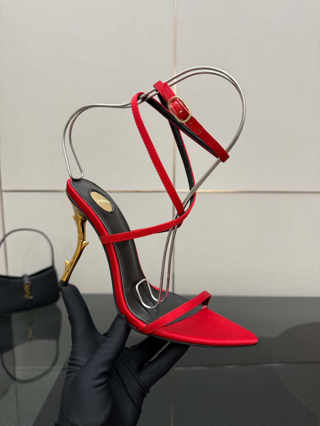 YSL ladies red and black strappy sandal close-up with gold stiletto heel and ankle laces