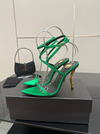 Green strappy heeled sandals with crisscross ankle straps and slim gold-toned heel