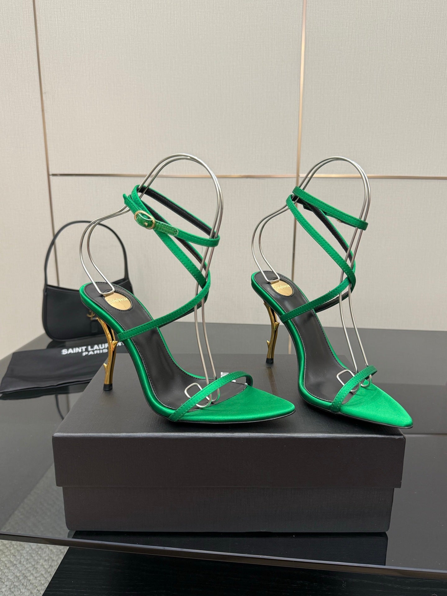 Green strappy high-heel sandals with thin ankle straps and gold-toned stilettos