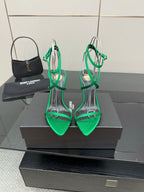 Green strappy pointed-toe sandals with thin ankle straps and gold-toned stiletto heel