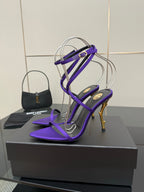 Pair of purple strappy high-heel sandals on a shoe box, open-toe design