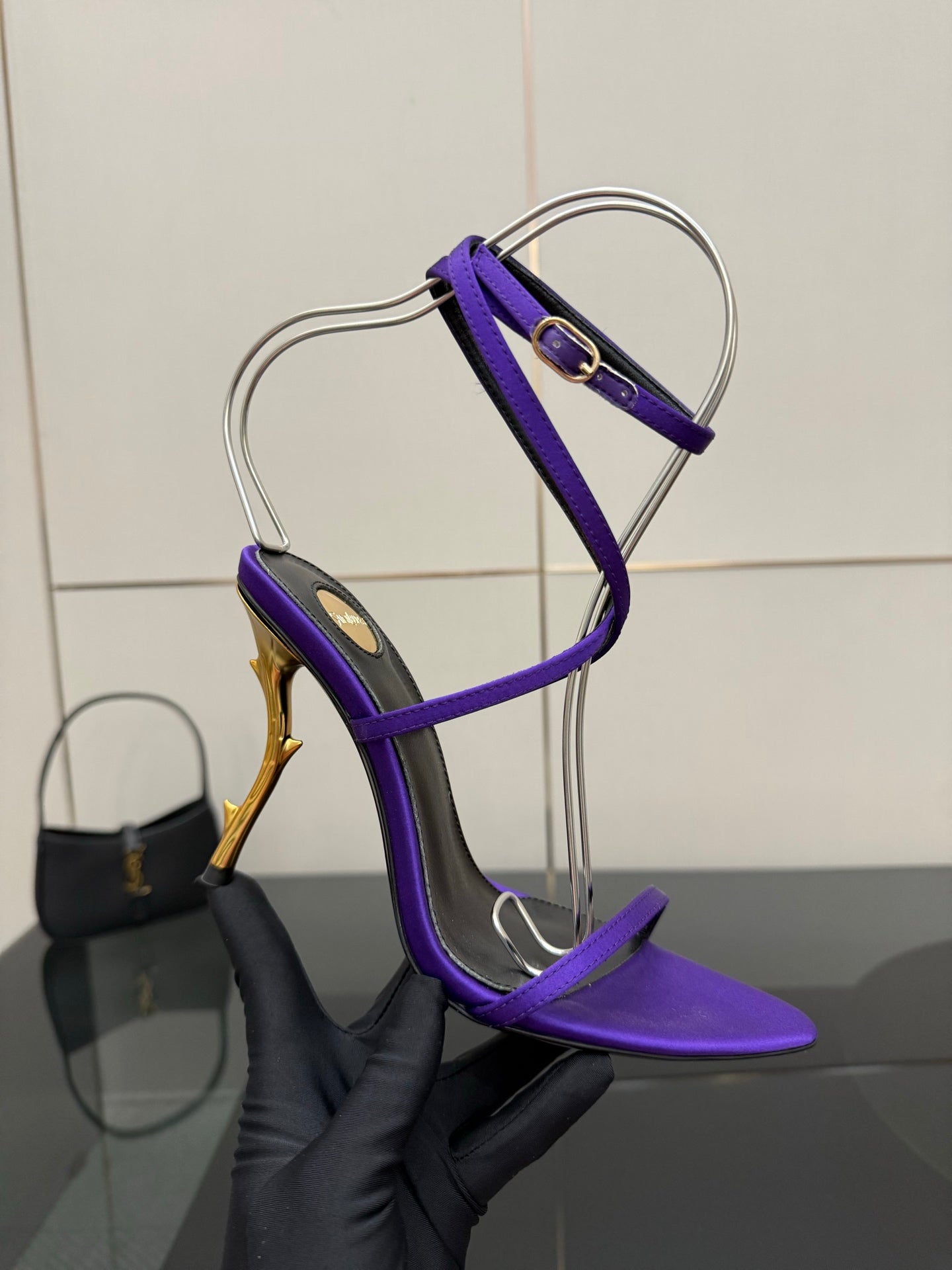 Purple strappy high-heel sandal with gold-tone stiletto heel, side profile