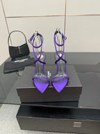 Purple strappy high-heel sandals with thin crisscross ankle straps and stiletto heels