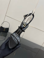 Black pointed-toe strappy sandal with ankle sling straps and gold-tone stiletto heel.