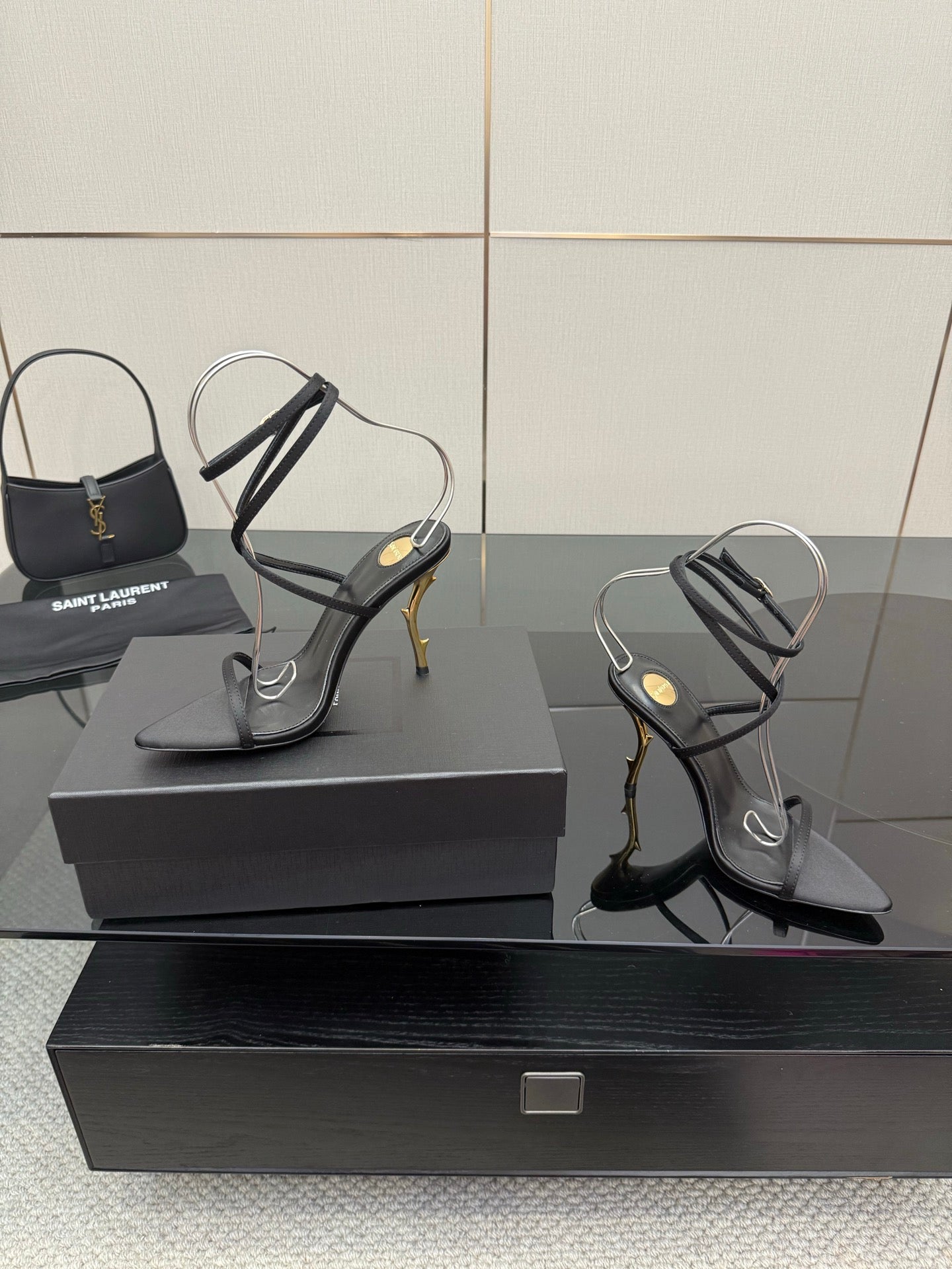 Black strappy high-heel sandals with ankle sling straps and gold-tone stiletto heels.
