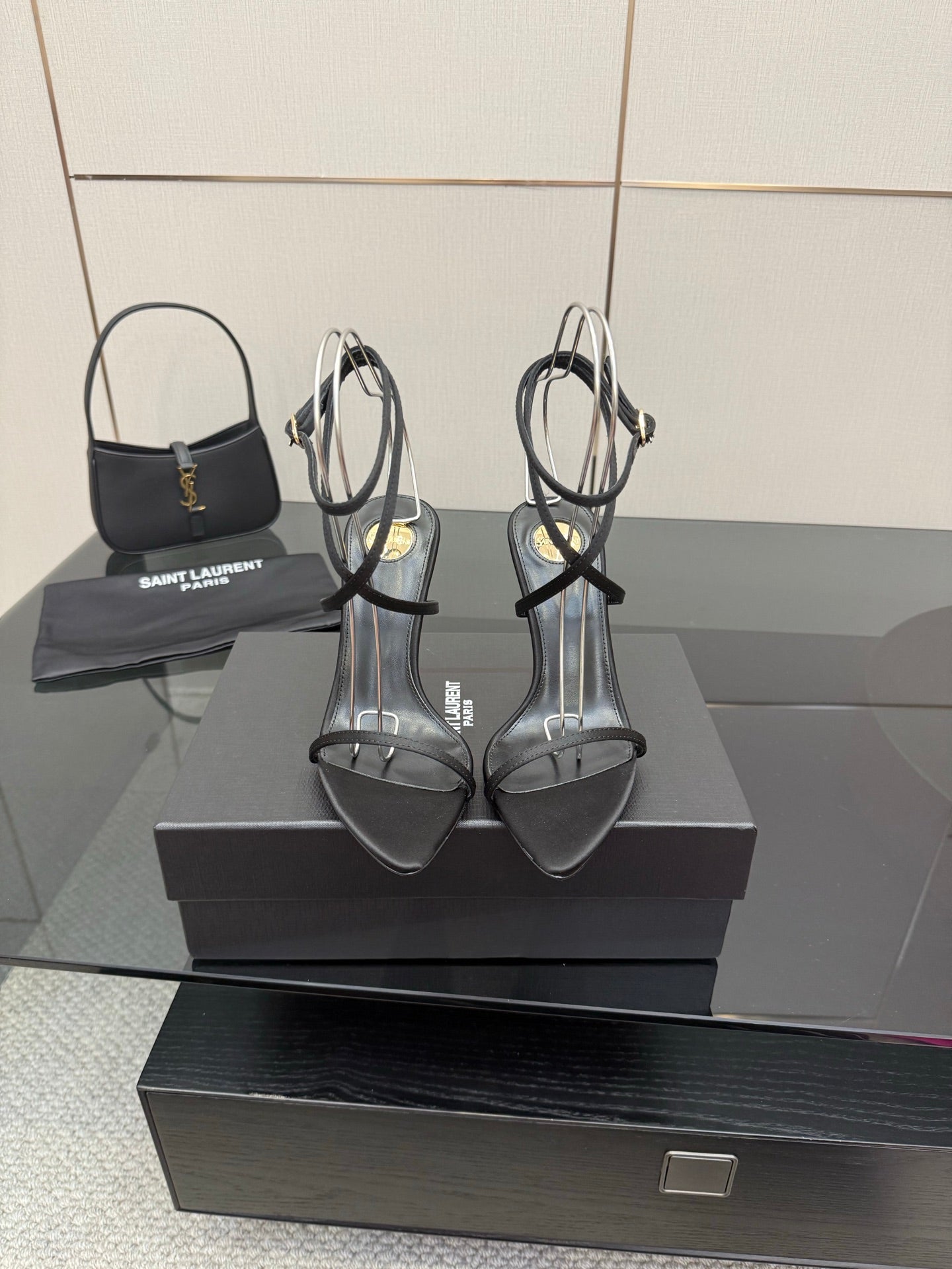 Black strappy high-heel sandals with thin toe and ankle straps and gold-tone heels.