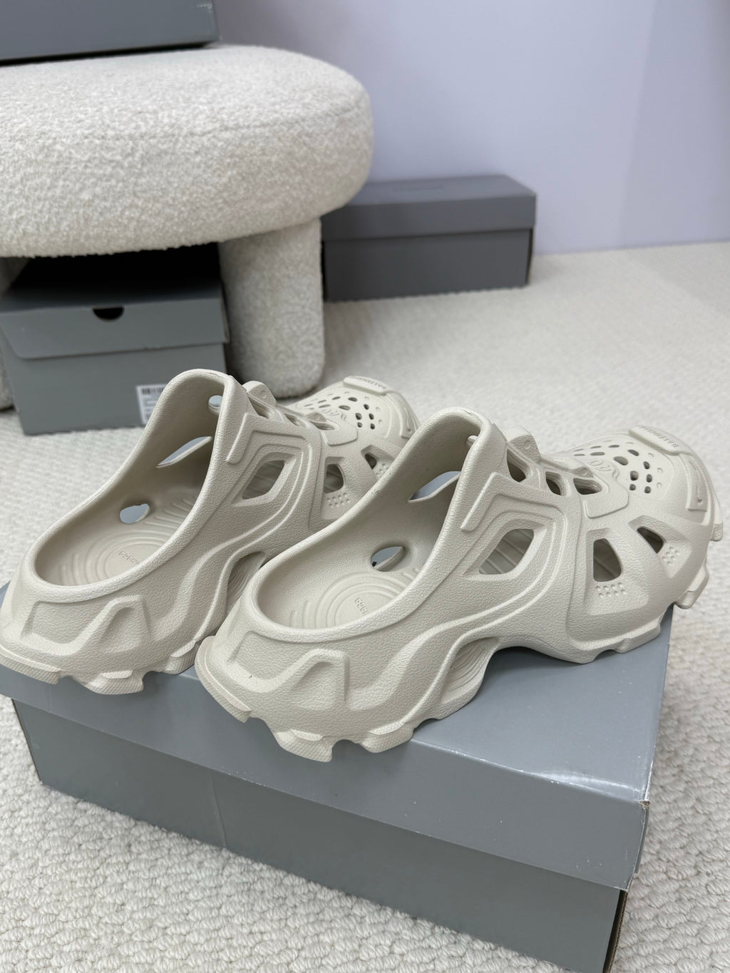 Balenciaga white slide sandals, two shoes on display with perforated toe