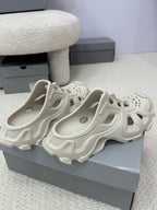 Balenciaga white slide sandals, two shoes on display with perforated toe