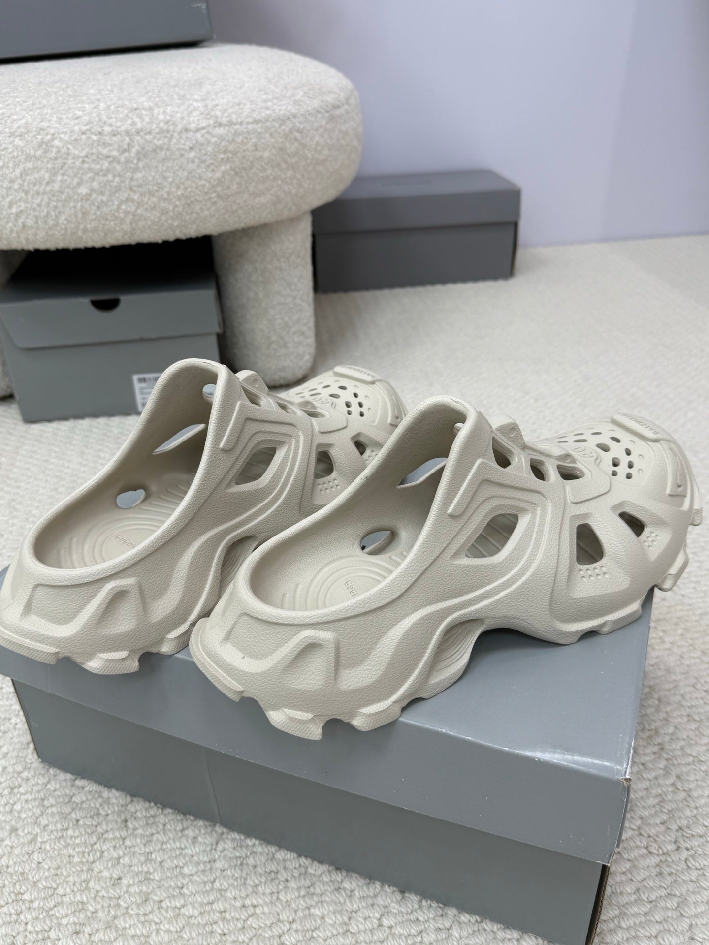 Balenciaga white slide sandals, two shoes on display with perforated toe