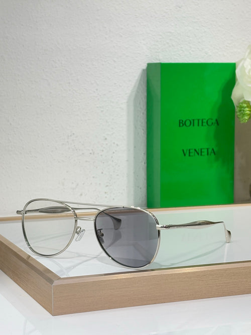 Round sunglasses with clear silver frame and dark gray lenses.
