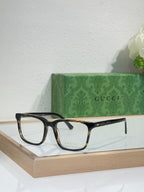 Gucci eyeglasses with dark rectangular frame and gold-tone logo temples