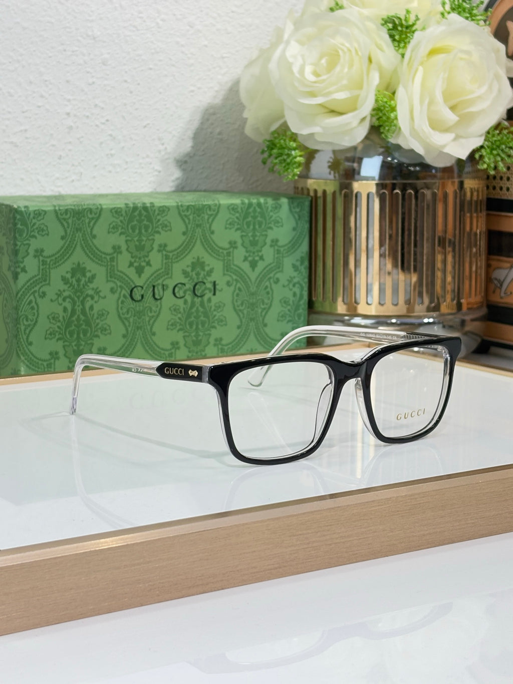 Gucci eyeglasses with black rectangular frame and clear lenses, side-by-side view