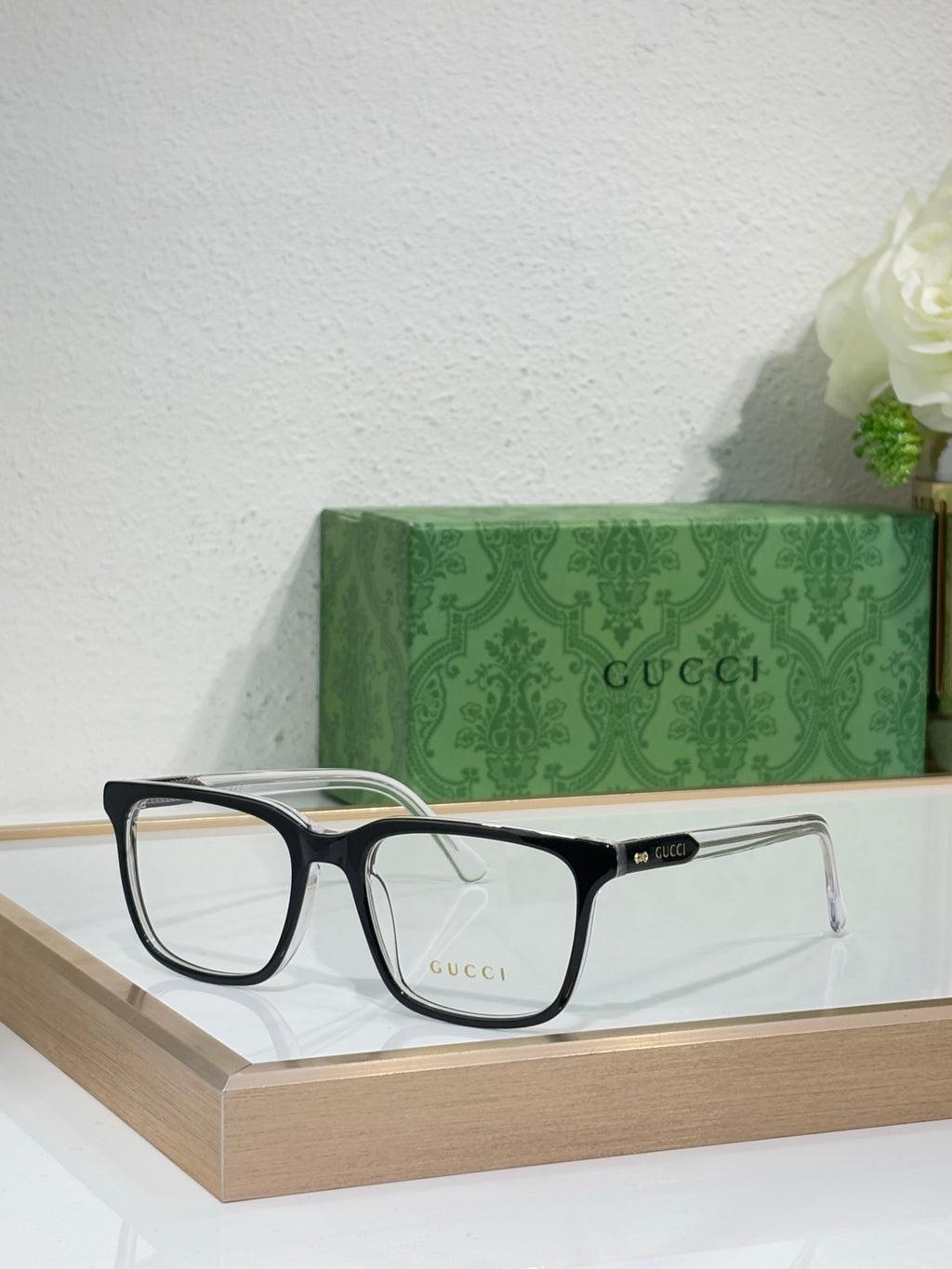 Gucci eyeglasses with black rectangular frame and clear lenses, angled front