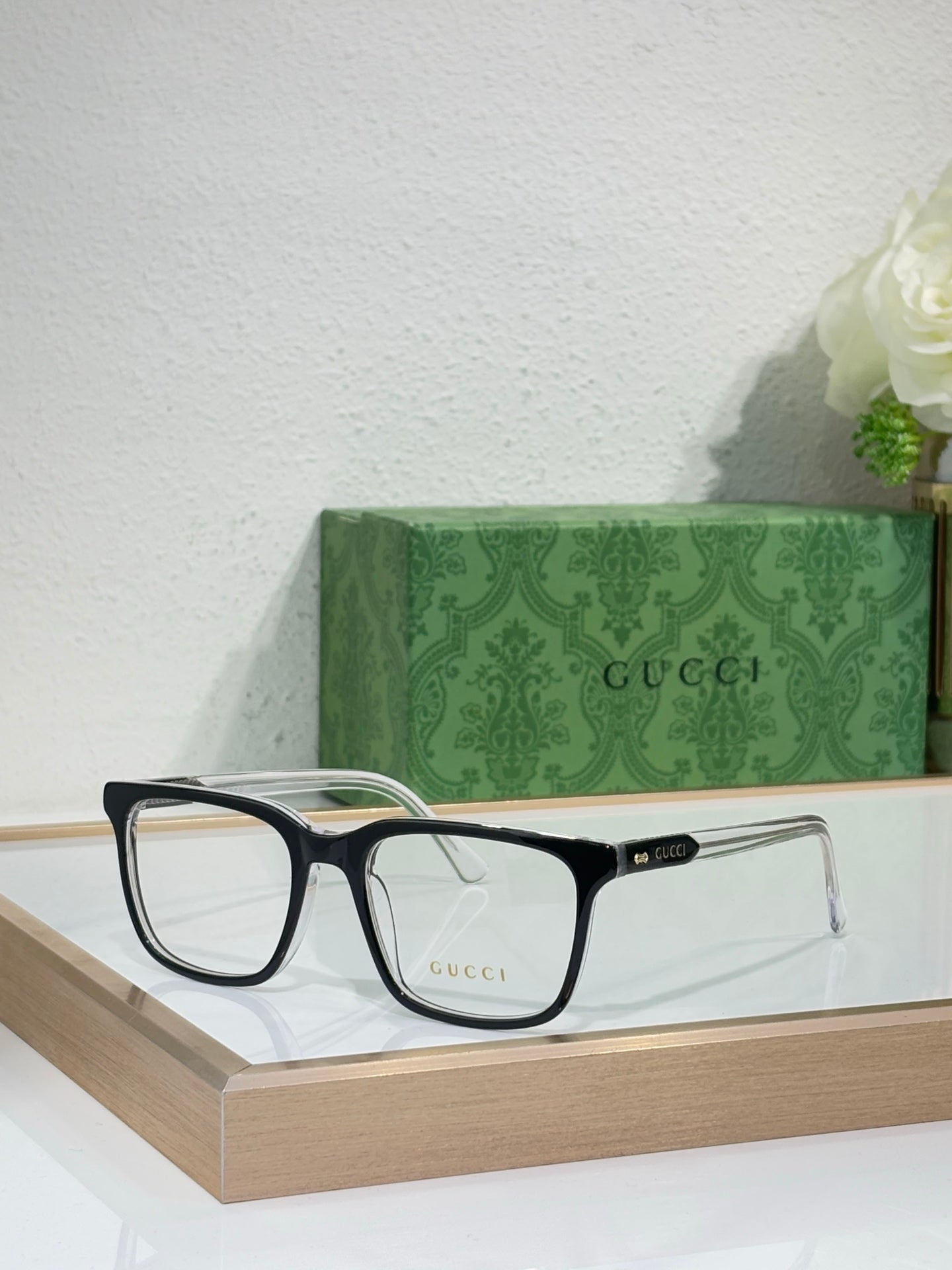 Gucci eyeglasses with black rectangular frame and clear lenses, angled front