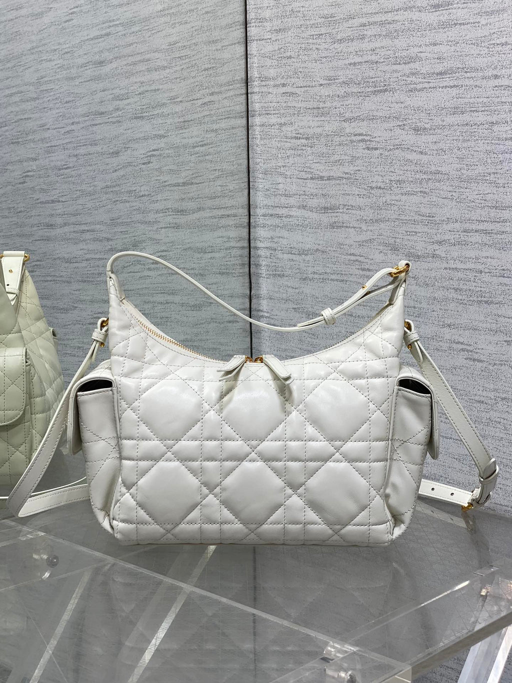 White quilted shoulder bag with structured shape and white crossbody strap