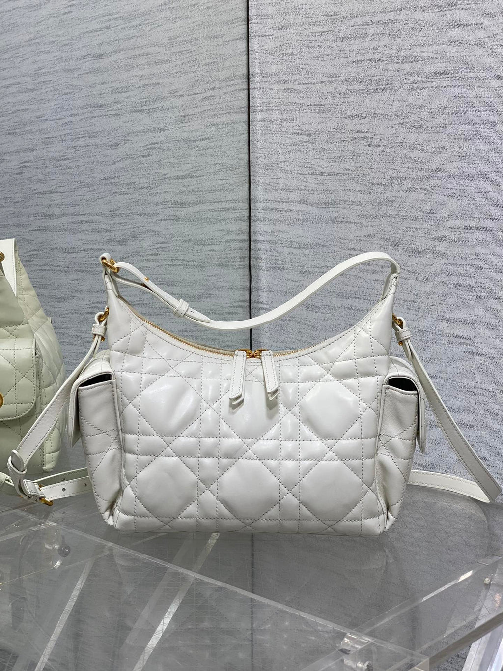 White quilted shoulder bag with gold-tone hardware and adjustable crossbody strap