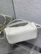 White quilted baguette crossbody bag with curved zipper top and slim strap