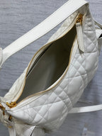 White quilted bag with zipper open to show dark green interior lining