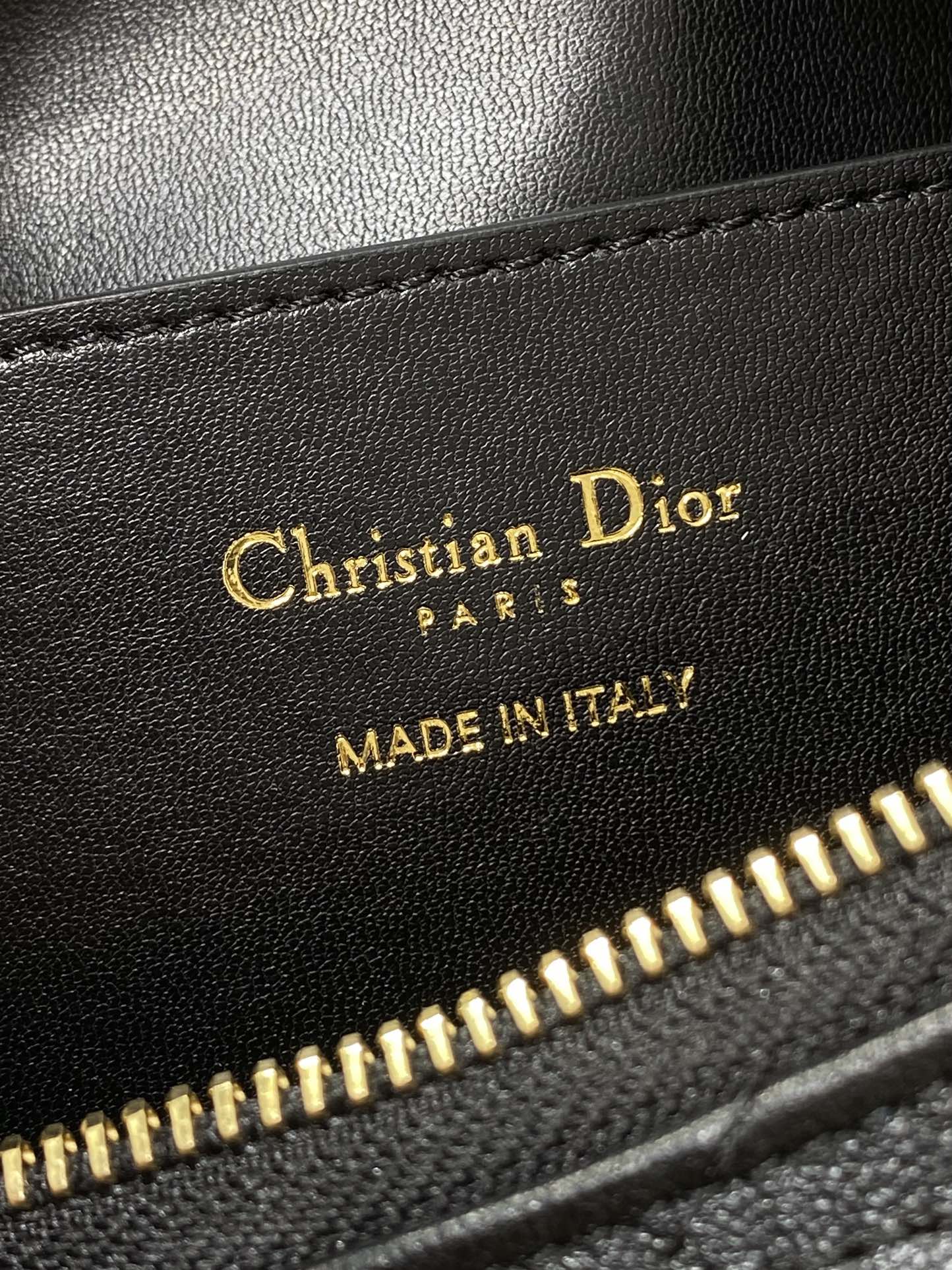 Leather bag label reading Christian Dior, MADE IN ITALY, near gold zipper