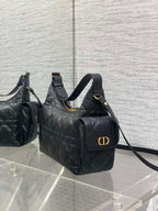 Black quilted shoulder bag with front pocket, top handle, and gold-tone logo clasp