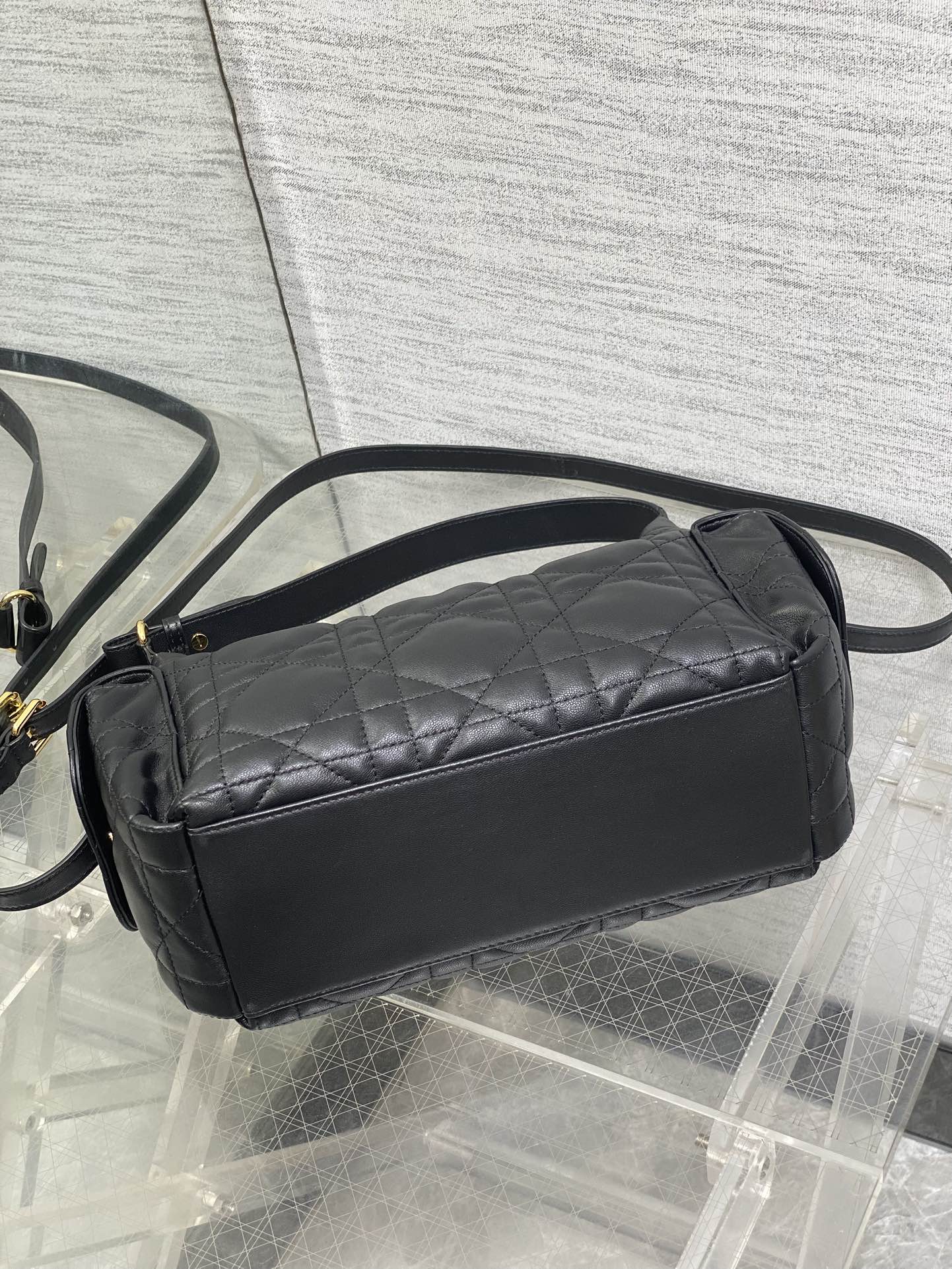 Black quilted mini shoulder bag with top zip and adjustable shoulder strap