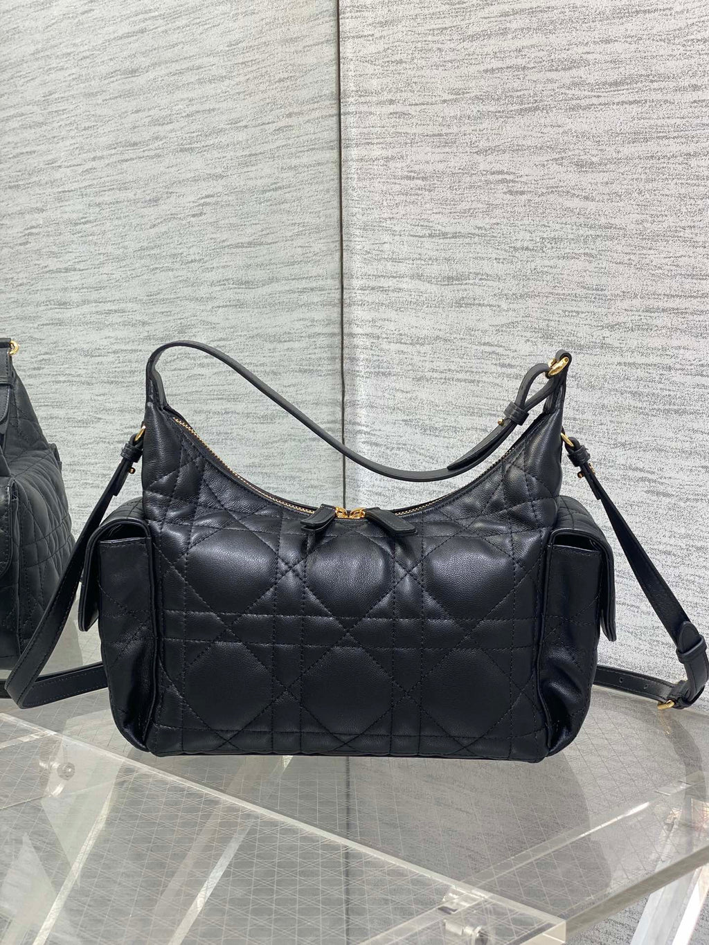 Black quilted hobo bag with top handle, shoulder strap, and gold-tone trim