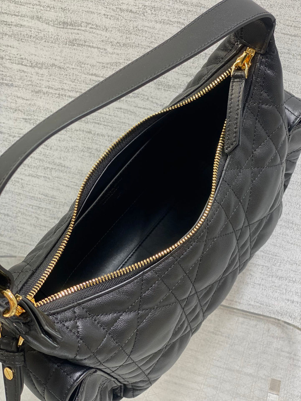 Black quilted bag interior close-up with gold zipper and dark fabric lining