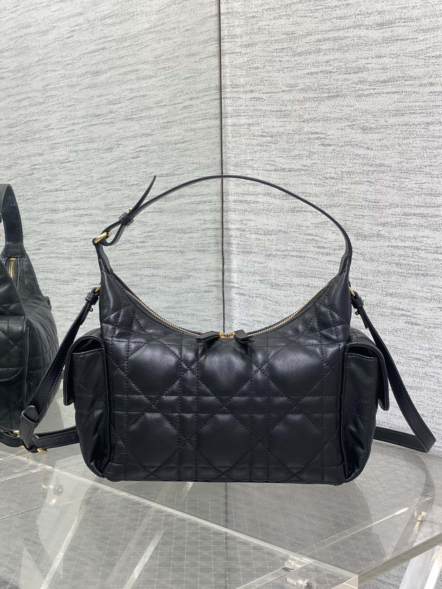 Black quilted hobo bag with top handle, shoulder strap, and gold-tone hardware