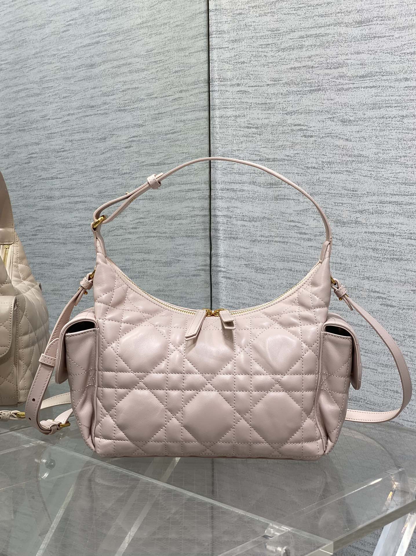 Light pink quilted shoulder bag with gold-tone hardware and top zipper