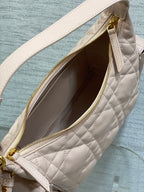 Light pink quilted bag interior with gold zipper and stitched trim