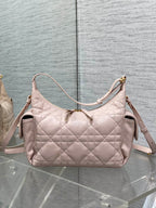 Light pink quilted shoulder bag with adjustable strap and side zipper pockets