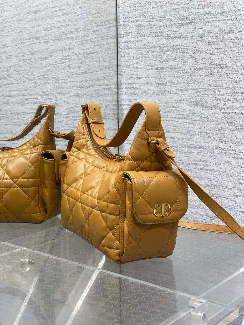 Dior quilted leather mini bag set on display, one with D-ring front and strap