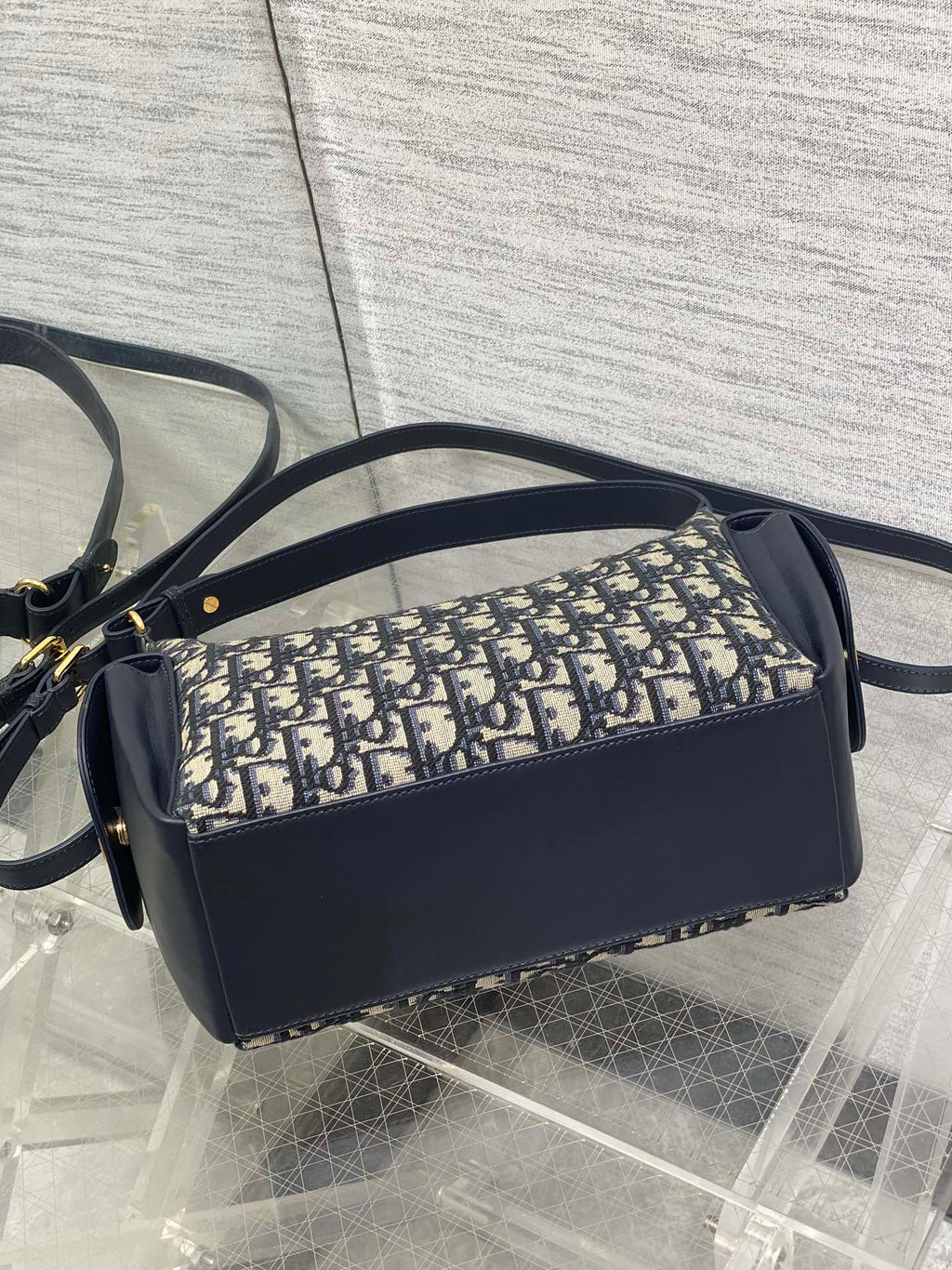 Dior shoulder bag side view with Dior Oblique canvas panel and navy leather trim