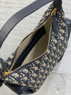 Dior Oblique canvas bag open-top detail with navy lining and gold zipper, close-up