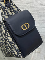 Dior shoulder bag front flap with navy leather and gold CD emblem, close-up